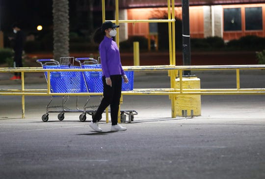 A woman wears gloves and a mask while grocery shopping